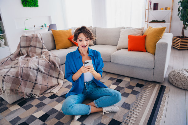 照片中的女孩坐在客厅的地毯上，在室内阅读意想不到的新闻图片下载