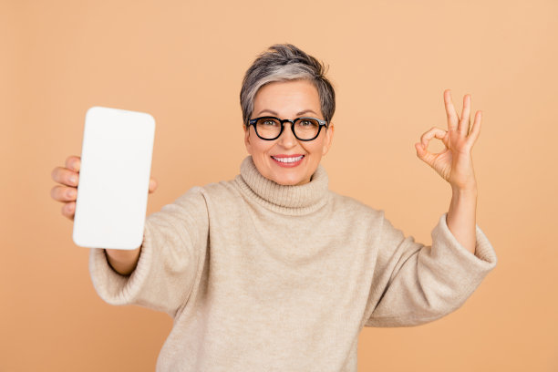 老年商务妇女穿毛衣的照片示范推荐好工作服务电话显示孤立的米色背景图片下载