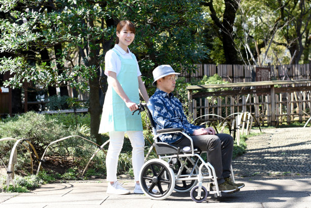 亚洲女护工与坐轮椅的老人同行图片下载