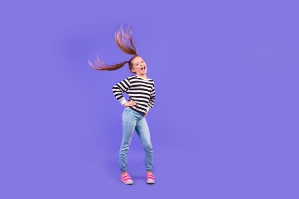兴奋漂亮的小孩穿条纹毛衣有乐趣跳舞空空间孤立的紫罗兰色背景的全长照片图片下载
