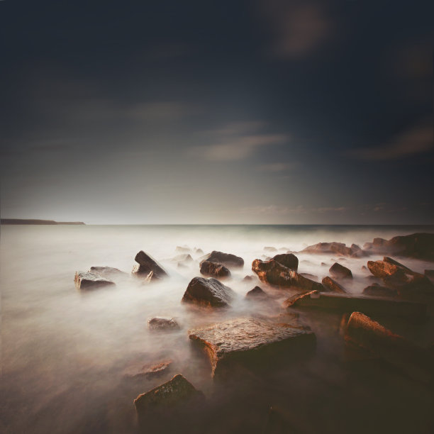 采用长曝光技术拍摄，描绘了淹没在海中的方形岩石。库存图片图片下载