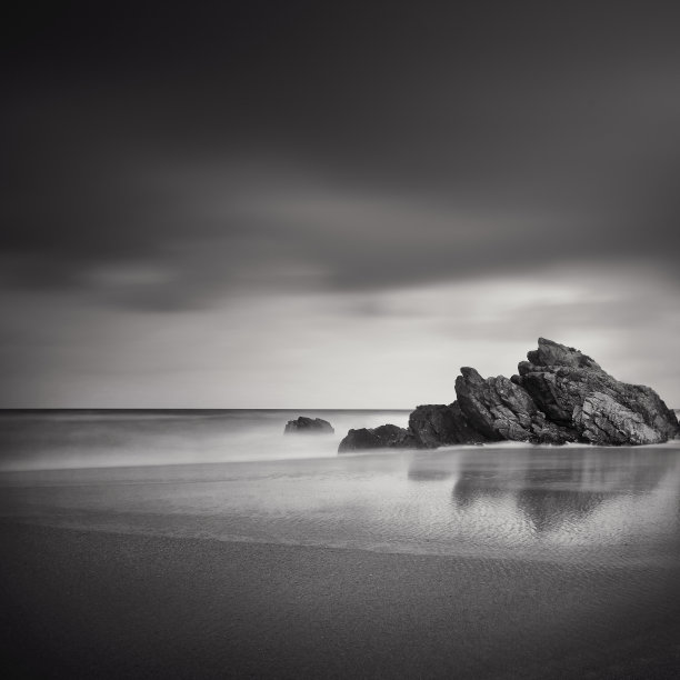 海边岩石海岸在水面上的倒影。库存图片图片下载