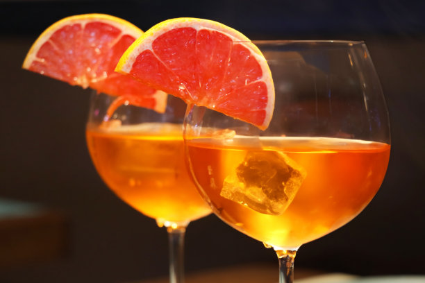 两种斯普利茨威尼斯鸡尾酒的特写图片，用橘子片、普罗赛克、消化苦味酒、苏打水和冰块装饰，用餐背景，重点在前景图片下载