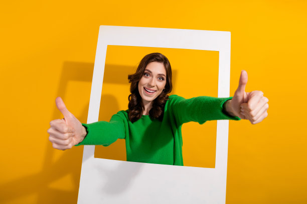 照片中的小女孩友好地竖起了两个大拇指，被批准参加封闭的贵宾聚会，她在纸框里，被隔离在黄色背景上图片下载