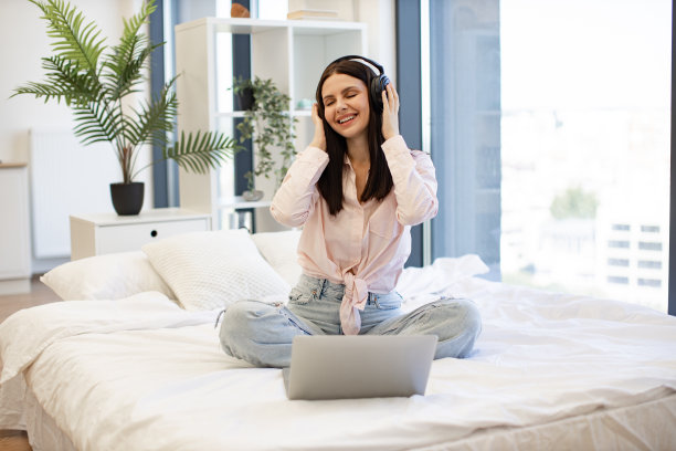 带着无线耳机微笑着的黑发女人在听着最爱的歌。图片下载