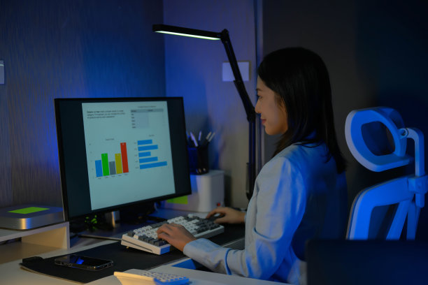 年轻勤劳的女商人晚上在办公室加班的照片。图片下载