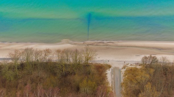 无人机拍摄的波兰西波美拉尼亚省加斯基海滩。这张照片展示了波罗的海蓝绿色的海水、宽阔的沙滩和沙丘上光秃秃的树木。二月冬天被俘。图片下载