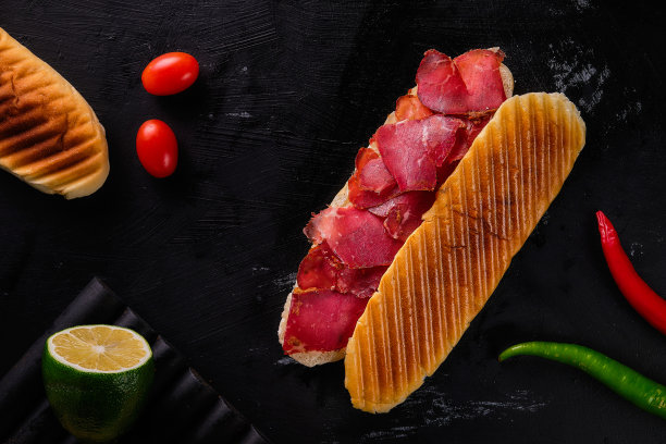 俯视图照片的熏牛肉三明治在一个黑色的背景图片下载