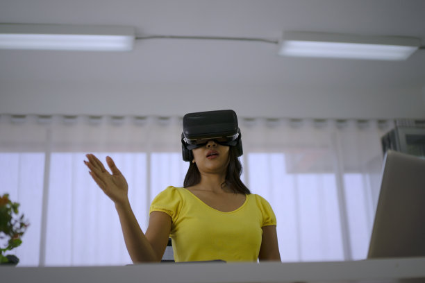 年轻女子使用虚拟现实眼镜进行演示。图片下载