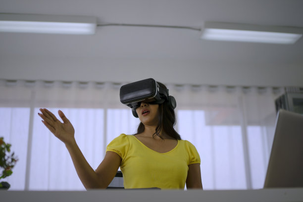 年轻女子使用虚拟现实眼镜进行演示。图片下载