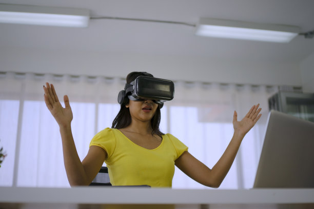 年轻女子使用虚拟现实眼镜进行演示。图片下载