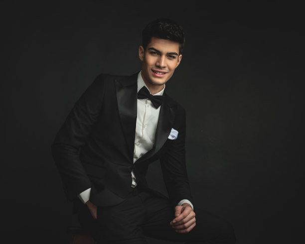 年轻的新郎坐在那里，手插在口袋里，面带微笑图片下载