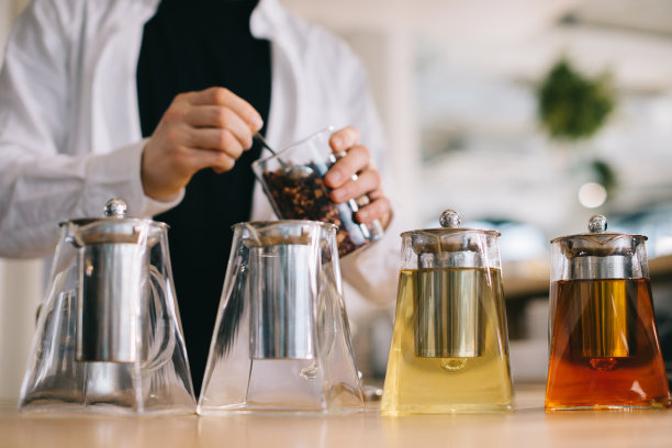 一位年轻的咖啡师在一家现代咖啡馆准备美味的茶。图片下载