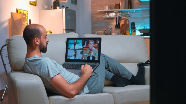 穿着睡衣的商人躺在沙发上和朋友聊天图片下载