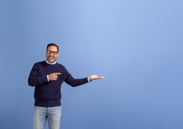在蓝色背景上推销新产品时，欣喜若狂的推销员指着并展示空手图片下载