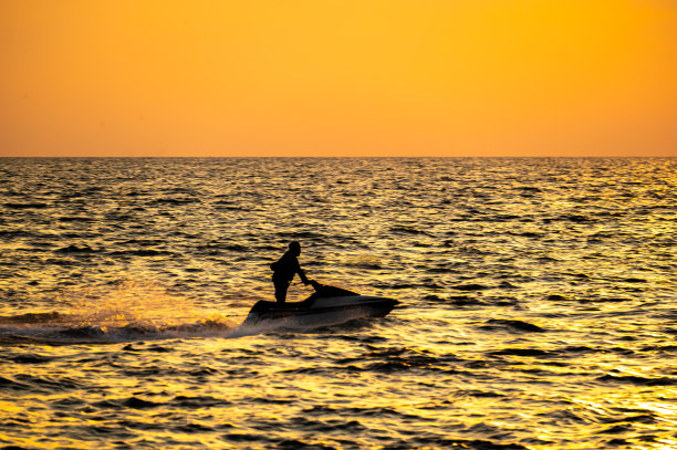 火热的地平线，戏剧性的海洋日落在黑暗的水域上充满活力的色调，大自然令人惊叹的照片反映了黄昏的宁静奇观和海岸美景的艺术性图片下载