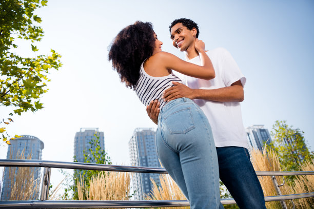 好心情可爱的已婚夫妇穿着休闲装拥抱在城市公园户外散步的照片图片下载