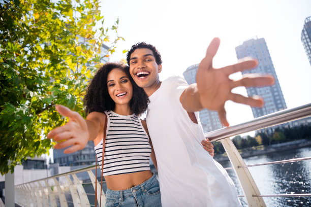 照片中欢快、积极、高兴、友好的人们看着相机，双手张开，阳光明媚的季节站在外面图片下载