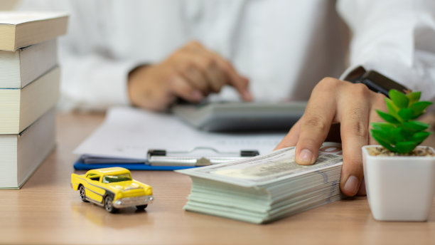 特写:手给车钥匙和钱，用于贷款、信用金融和租赁。汽车贷款概念，汽车换现金概念，金融概念。买卖新车或二手车。车钥匙在桌子上。图片下载