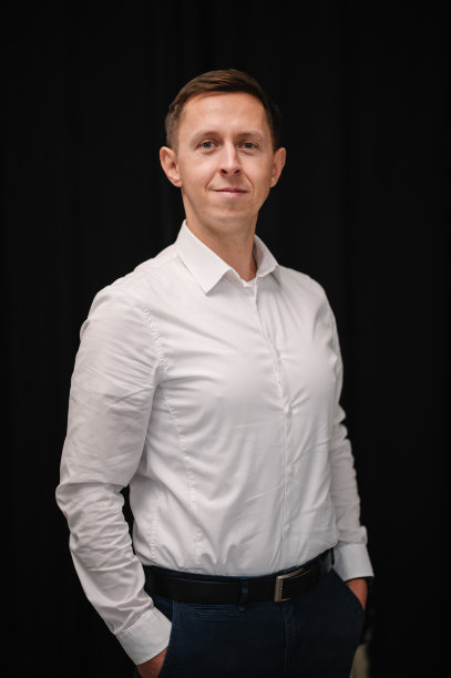 一个商人在早上为一个工作日的特写镜头做准备。英俊快乐的男人在房间或工作室。黑色墙上一个男人的肖像。新郎穿着衬衫。时尚经典男装。图片下载