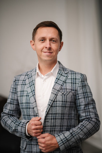 英俊快乐的男人在房间或工作室。人的肖像。男人用手扣钮扣。新郎穿西装和衬衫。时尚经典男装。一个商人在早上为一天的工作做准备。图片下载