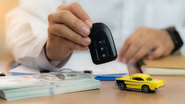 特写:手给车钥匙和钱，用于贷款、信用金融和租赁。汽车贷款概念，汽车换现金概念，金融概念。买卖新车或二手车。车钥匙在桌子上。图片下载