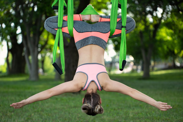 反重力瑜伽，一个女人在公园里做瑜伽。图片下载