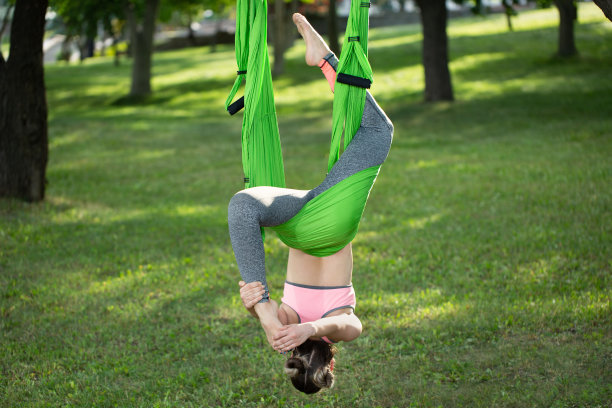 反重力瑜伽，一个女人在公园里做瑜伽。图片下载