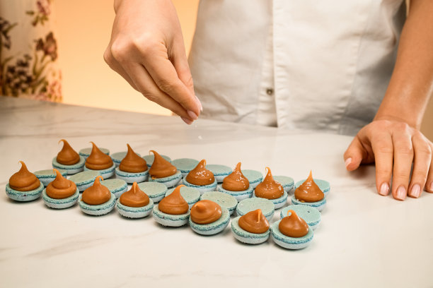 在一张白色的桌子上由一位烹饪专家做马卡龙图片下载