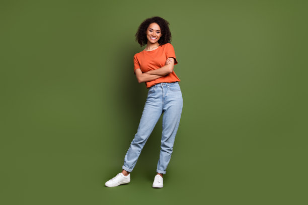 漂亮可爱的女士全身照片穿着橙色t恤手臂折叠空空间孤立卡其色背景图片下载