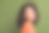 照片中闪亮梦幻的女士穿着橙色t恤微笑着回头看空旷孤立的卡其色背景图片下载