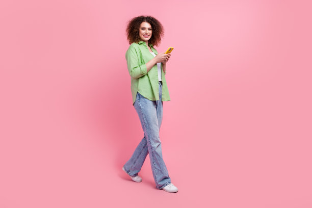 正面办公室女经理的全身照片控制过程在网上使用手机隔离在粉红色背景图片下载