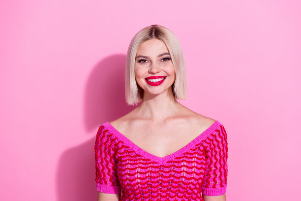 照片可爱可爱的女孩灿烂的微笑明亮的红色口红针织品孤立在粉红色的背景图片下载