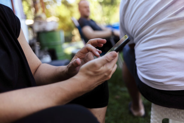 在社交媒体、移动应用程序或互联网上的手机网络上拍摄的手和女性特写照片。科技、自然和女性在农村用手机发短信。图片下载