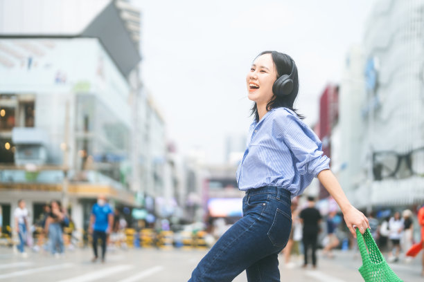 年轻的成年亚洲女性戴着无线耳机城市人的生活方式与积极的自爱图片下载