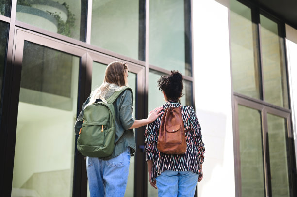 两个女学生在看大学大楼。图片下载