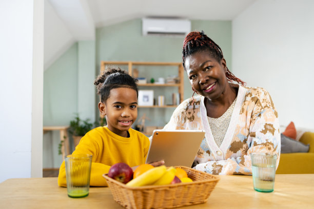 一个小非洲裔美国男孩和他的奶奶享受和使用平板电脑的肖像图片下载