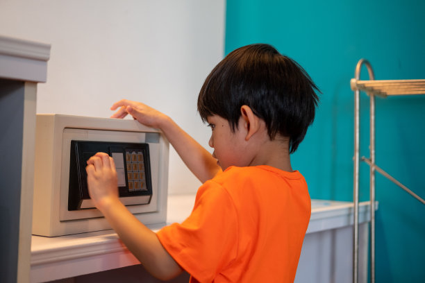 亚洲小男孩在家打开保险箱图片下载