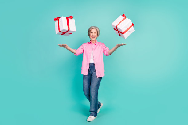 照片中，迷人快乐的祖母穿着粉色时髦的衬衫，拿着青色背景的标牌，享受着买打折的乐趣图片下载