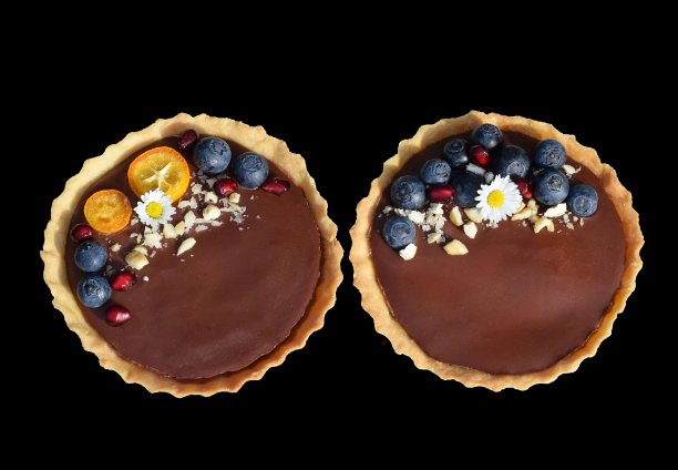 酥饼馅饼配巧克力布丁，新鲜蓝莓，石榴籽，金桔片，腰果和可食用的雏菊花图片下载