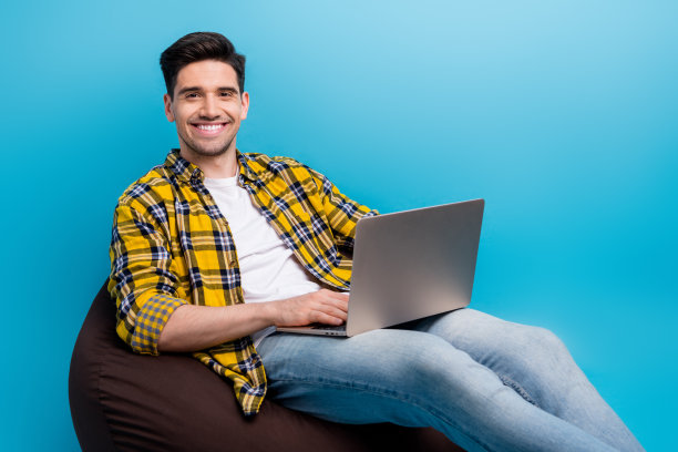 英俊的年轻人的照片，它的专家工作远程编程，他自己的网站上孤立的初级程序员的蓝色背景图片下载