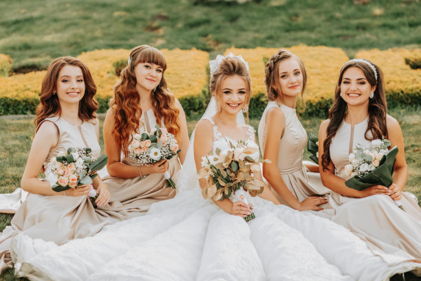 新娘和伴娘拿着婚礼花束的照片。结婚的那一天。在闺蜜婚礼上开心的女孩。美丽的新娘和她的朋友们。夏天的婚礼图片下载