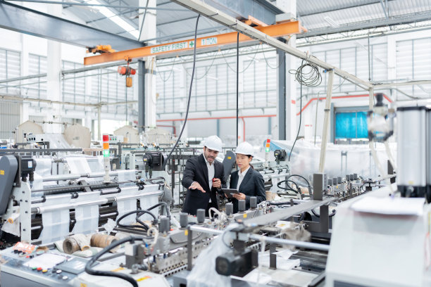 在网站上进行图片推广和全球塑料工厂营销。有男性也有女性的欧洲和亚洲工程师。穿上制服，戴上头盔。被商业机器包围图片下载