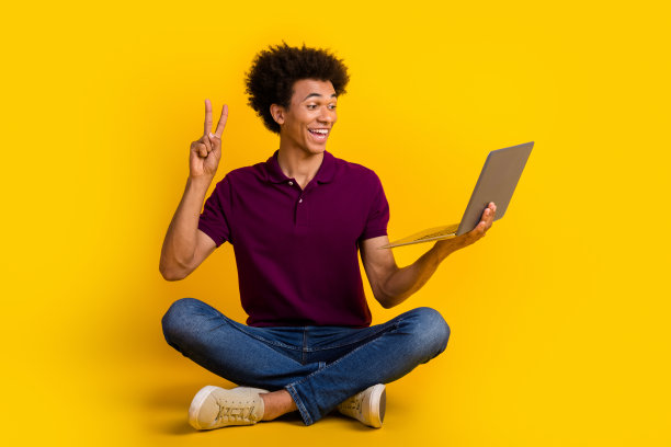 照片的好积极的人坐在地板上聊天，谈论视频电话会议的v字孤立的黄色背景图片下载