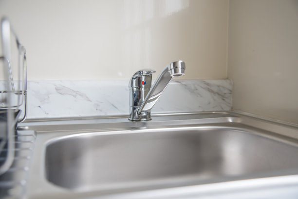 厨房面盆，有晾晒盘子的空间，展示闪亮的镀银水龙头和管道。图片下载