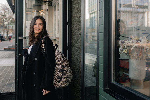 可爱的韩国女孩拿着礼品盒在靠窗的咖啡馆里喝咖啡的照片。十几岁的女孩在城市里散步，玩得很开心。旅游、度假、度假理念图片下载