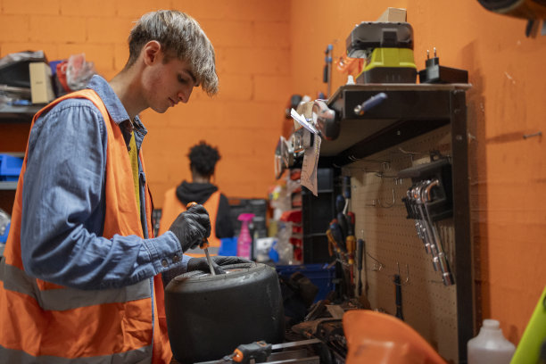 卡丁车机械厂年轻机械师修理轮胎图片下载