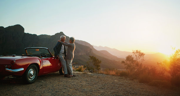 一对深情的老年夫妇在公路旅行中欣赏日落的照片图片下载