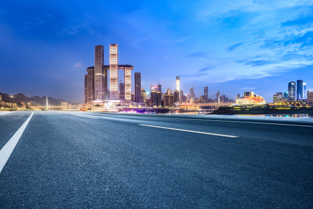 空旷的柏油路和夜晚的城市建筑天际线图片下载