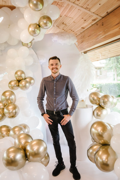 男子庆祝生日聚会。男照片墙附近的空间或地方装饰用白色和金色气球。生日装饰-气球，白色背景的男孩聚会装饰。图片下载